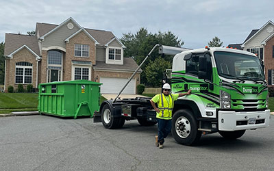 Image of dumpster being delivered by driver